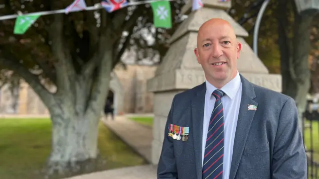 aul Vane wearing his granddad's war medals before church service in St John's parish