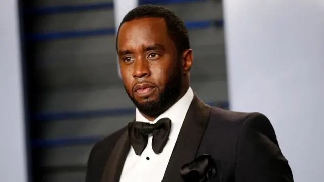 Sean Combs wearing a tuxedo with black jacket, white shirt and bowtie.