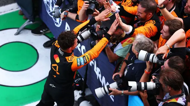 Lando Norris celebrating with the McLaren team