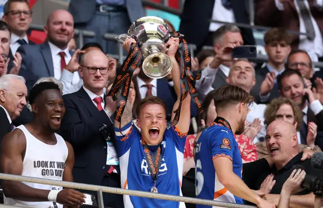 Tom Conlon of Oldham Athletic lifts the trophy