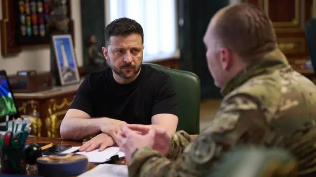 Ukrainian President Volodymyr Zelensky (L) speaking with the Head of the Security Service (SSU) Vasyl Malyuk (R) during their meeting in Kyiv