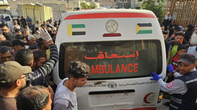 An ambulance drives through a crowd of people to the Nasser Hospital in Gaza.