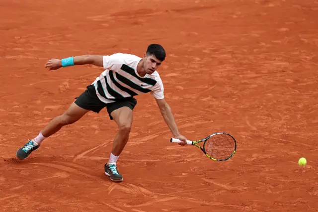 Carlos Alcaraz of Spain swaps the racket to his left hand