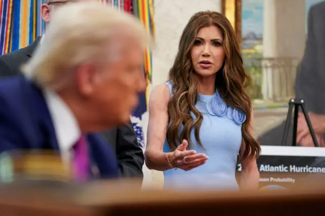 Kristi Noem speaking to President Trump in the Oval Office