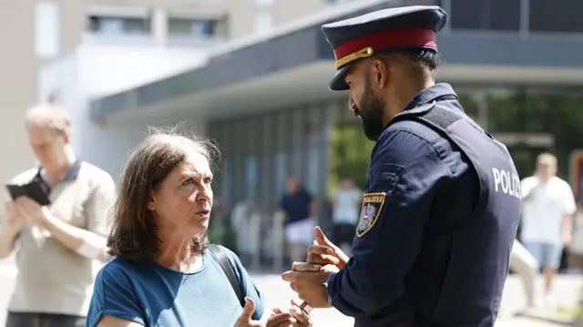 Graz mayor Elke Kahr talking to a policeman