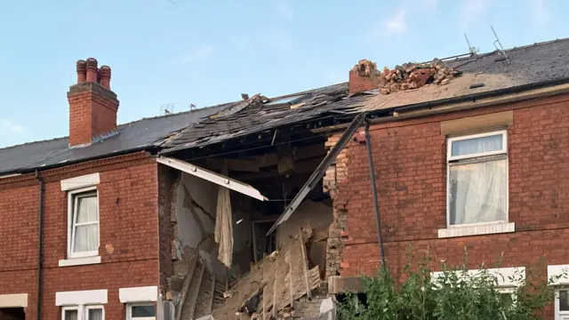 The exterior of a badly damaged terraced house