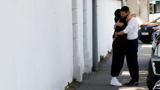 A man and a woman hug following deadly school shooting in Graz