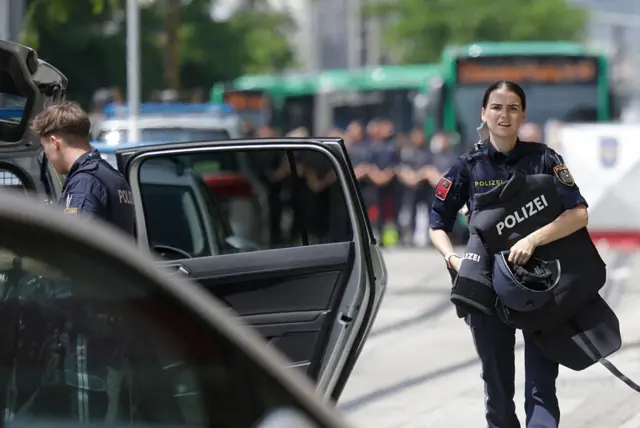 Police officers stand beside an emergency vehicle