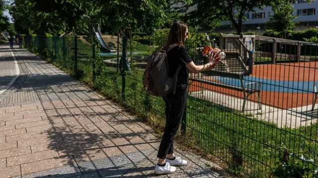 Person leaves flowers at school where shooting took place