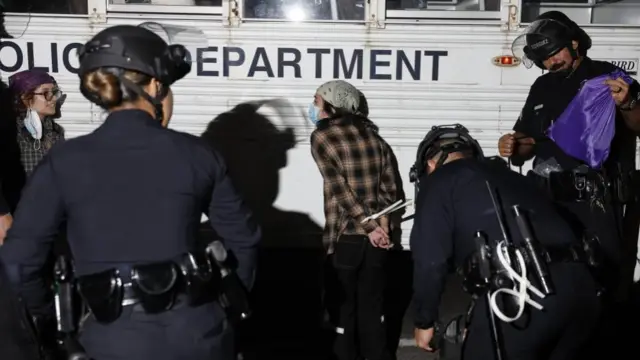 Los Angeles police officers detain individuals following clashes with protesters in Los Angeles