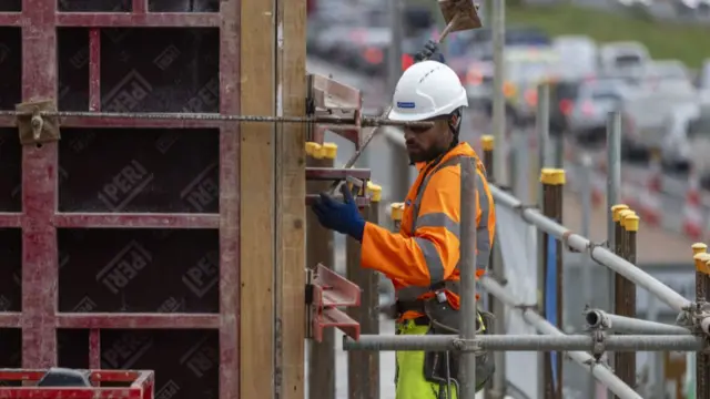 A worker on the upgrade to the M25 wearing a hard hat and reflective clothing