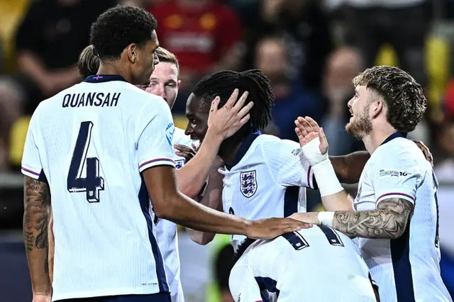 Rowe is congratulated by teammates after his goal