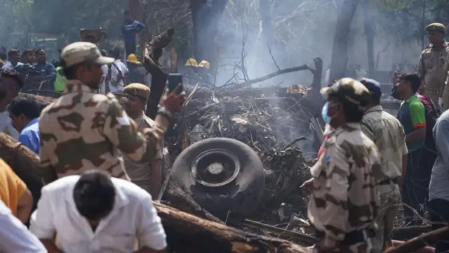 Officials inspect debris at the site of a plane crash - a wheel is seen amid the rubble