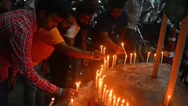 A group of people light candles