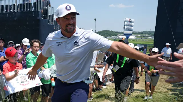 Bryson DeChambeau high-fiving fans at Oakmont