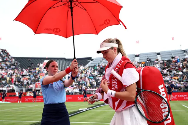 Katie Boulter under an umbrella
