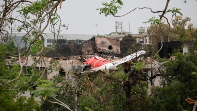 Part of a plane is on top of a destroyed building in India.