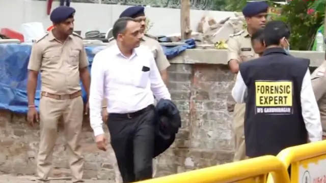 Members of a forensic team and police officials present at the crash site