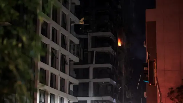 Fire burns in a building at an impact site following a missile attack from Iran on Israel