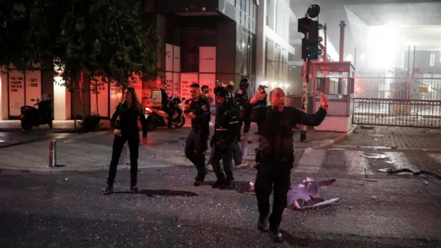 Security personnel react at an impact site following a missile attack from Iran on Israel
