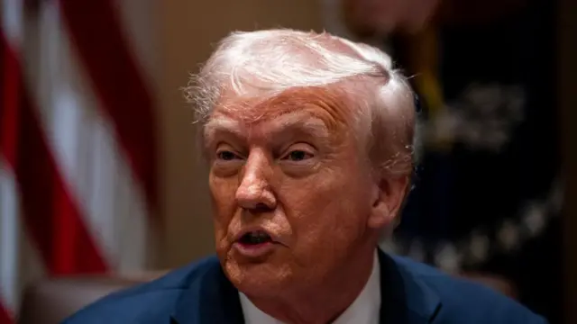 Headshot of Trump speaking with his mouth open as he looks to the side of the camera