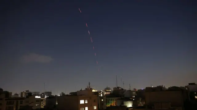 Air defence system activated in Tehran un the early evening. Photo is of the skyline of the Iranian capital, red flashes shooting through the darkening sky