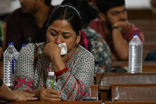 A woman seen waiting at the emergency centre, crying as she holds a bottle of water