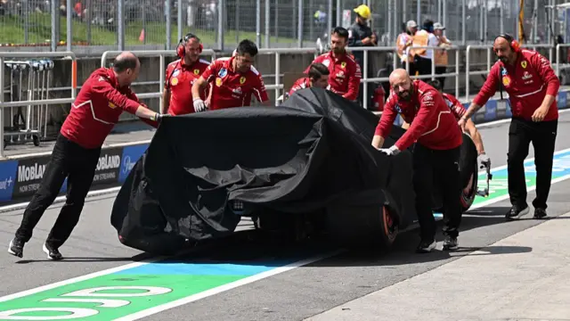 Charles Leclerc's damaged Ferrari is moved back into the garage