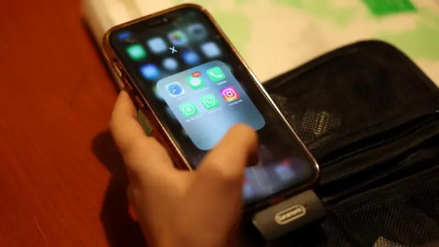 An Iranian woman uses her smartphone which has WhatsApp on it