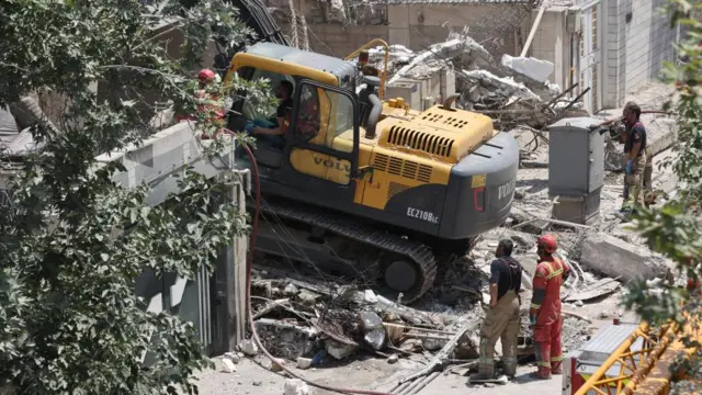 Heavy machinery works to move rubble at the site of an Israeli attack in Tehran.