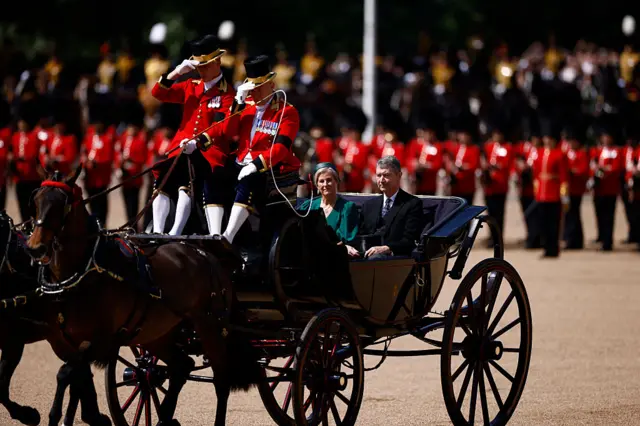 Britain's Sophie, Duchess of Edinburgh, and Vice Admiral Timothy Laurence arrive to Horse Guards Parade in a carriage surrounding by personnel.