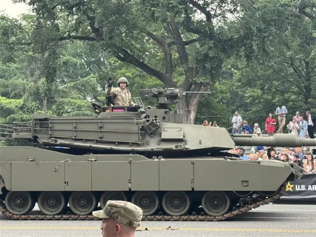 Soldiers in a tank wave to the crowd