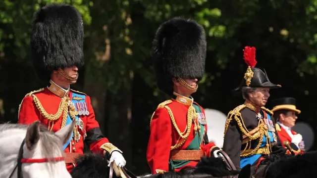 The Prince of Wales, The Duke of Edinburgh and the Princess Royal on horseback in military uniform.