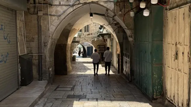 a quiet alley in the old city. two people can be seen but it is otherwise quiet