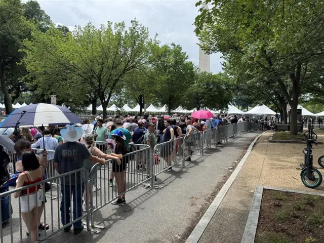 People line up to go through security checks to attend the parade.