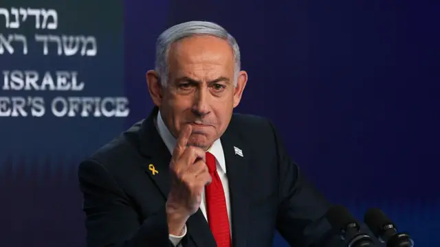 Benjamin Netanyahu gestures as he speaks from behind a podium.
