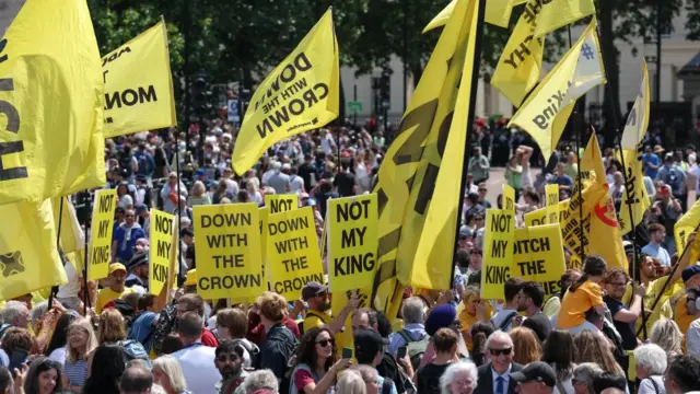Anti-monarchy protesters hold banners, on the day of the Trooping the Colour parade