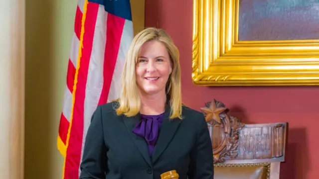 Melissa Hortman smiles wearing a blazer and purple top.