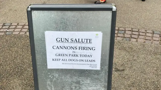 A warning sign in Green Park which reads: 'Gun salute, Cannons firing in Green Park today. Keep all dogs on leads".