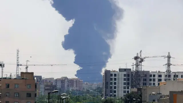 Smoke from an oil refinery rises over residential buildings in southern Tehran, Iran, 15 June 2025