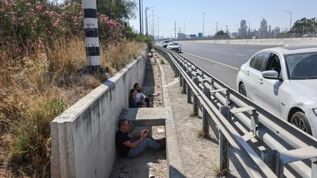 Israelis take cover beside a highway