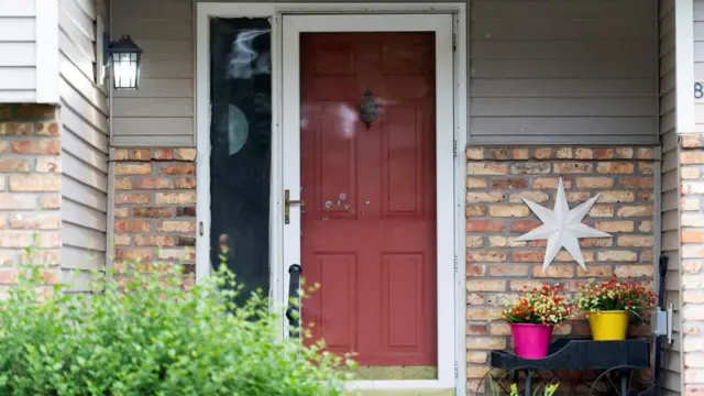 Bullet holes mark the front door of the Hoffman home