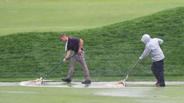 Clearing the 18th green of standing water