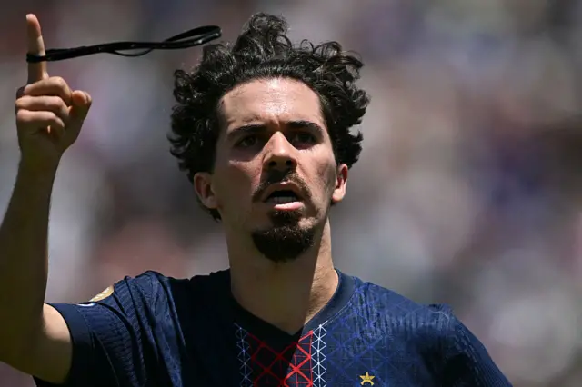 Vitinha celebrates his goal by twirling his headband around his finger