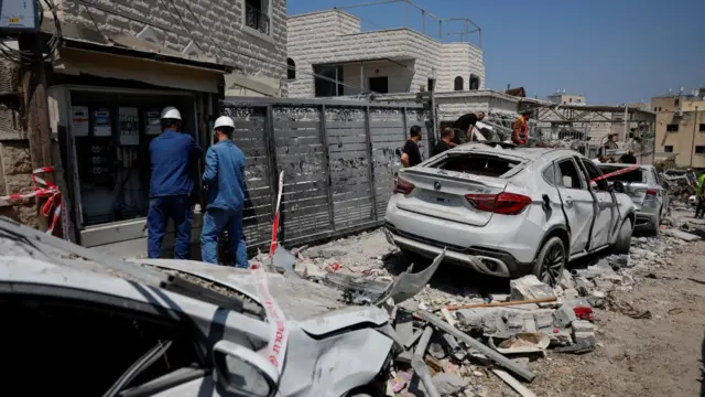 cars and rubble line a roadway in Tamra Israel