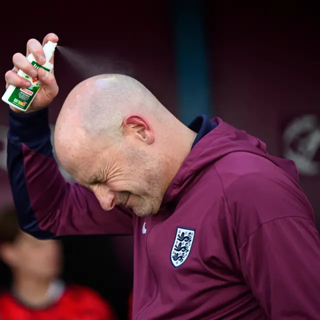 Carsley sprays bug spray on his head