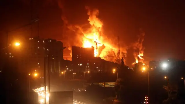 fire and smoke are shown over an iranian oil depot