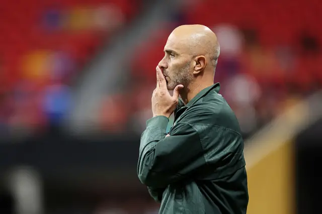 Enzo Maresca puts his hand over his mouth as he stands deep in thought