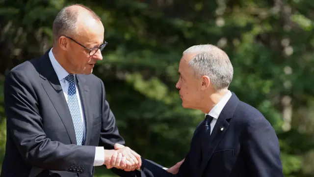 Mark Carney shakes hands with German Chancellor Friedrich Merz