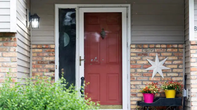 Bullet holes are shown on a red door door of Minnesota state Senator John Hoffman's home